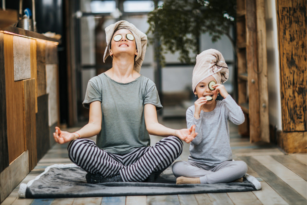 lady and daughter doing yoga with cucumbers on their eyes