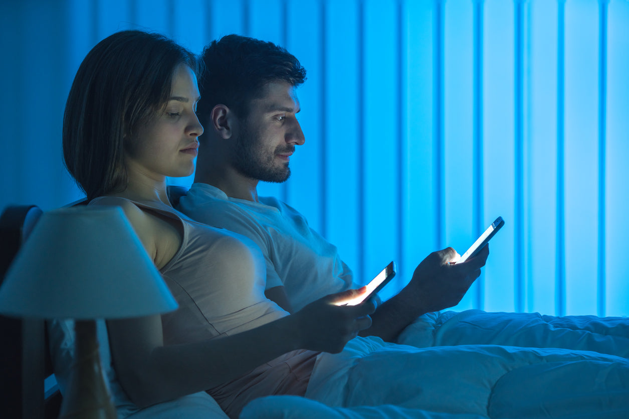 a man and a woman watching their phones in bed