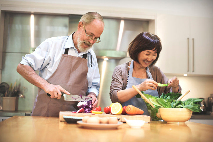 man and woman cooking a healthy meal